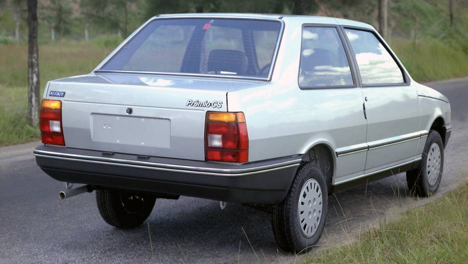 1985 - Primeira deriva&ccedil;&atilde;o de carroceria do Uno, o Pr&ecirc;mio &eacute; exclusividade nacional para aposentar o Oggi. Al&eacute;m do amplo porta-malas de 444 litros, o sed&atilde; de duas portas estreia o motor 1.5