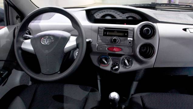 Modelo tem bancos de tecido reguláveis manualmente, ar-condicionado regulável, rádio com CD-Player e entrada USB <a href="https://quatrorodas.abril.com.br/salao-do-automovel/2012/carros/toyota-etios-703992.shtml" rel="migration">Leia mais</a>