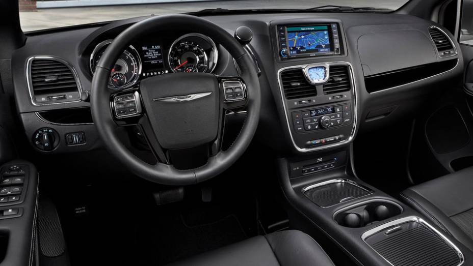 Por dentro, leitor de DVD e Blu-Ray para os passageiros do banco traseiro com entradas USB e HDMI | <a href="%20https://quatrorodas.abril.com.br/saloes/los-angeles/2012/chrysler-town-country-s-723717.shtml" rel="migration">Leia mais</a>