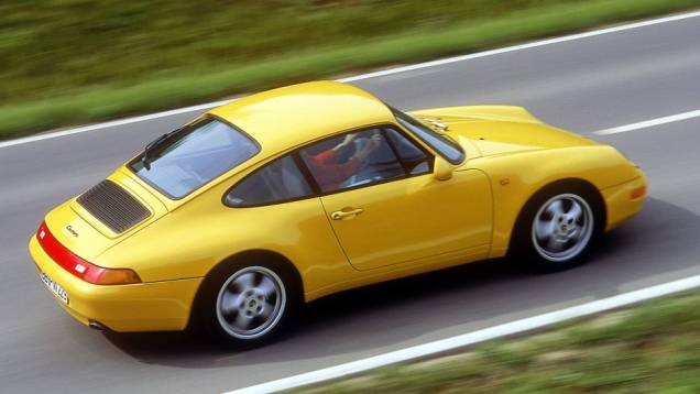 911 Carrera 1994 (993) - Os para-choques foram camuflados como parte da carroceria, tornando o desenho mais leve e moderno | <a href="%20https://quatrorodas.abril.com.br/reportagens/classicos/porsche-911-50-anos-748361.shtml" rel="migration">Leia mais</a>