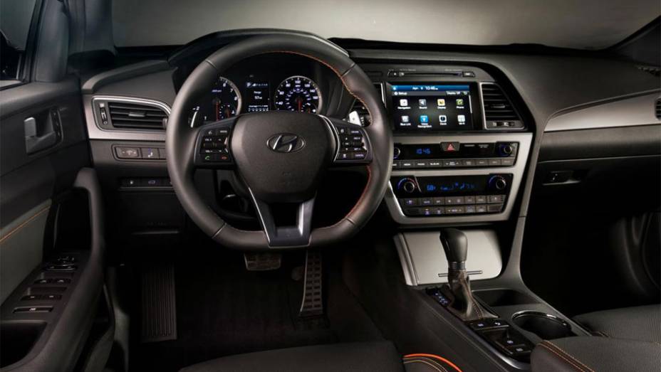 Seu interior é um pouco simples, mas vem muito bem equipado com ar condicionado e assentos de estofado premium | <a href="https://quatrorodas.abril.com.br/noticias/saloes/new-york-2014/hyundai-revela-sonata-2015-nova-york-779988.shtml" rel="migration">Leia mais</a>