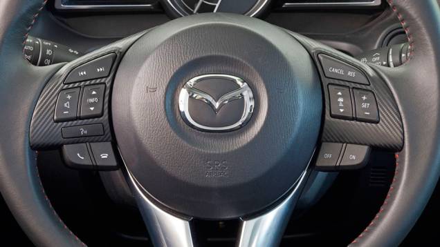 Detalhe do volante do novo Mazda3 Sedan | <a href="https://quatrorodas.abril.com.br/noticias/fabricantes/primeiras-fotos-oficiais-mazda3-sedan-2014-sao-reveladas-745927.shtml" rel="migration">Leia mais</a>