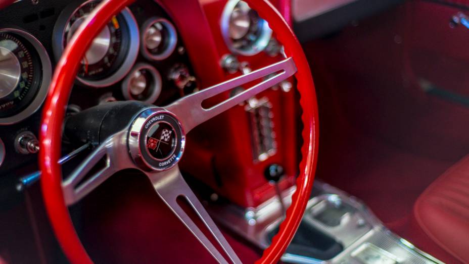 Todo vermelho, o interior do Corvette trazia o conceito de cockpit duplo, dividindo a cabine em duas seções | <a href="http://quatrorodas.abril.com.br/galerias/especiais/colecao-carros-antigos-parte-1-852734.shtml" target="_blank" rel="migration">Veja a parte 1</a> | <a href="" rel="migration"></a>
