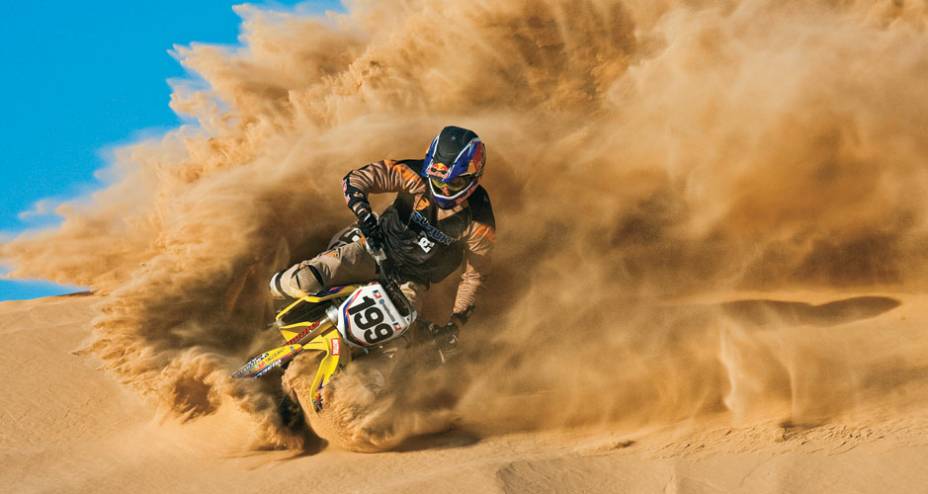 Pastrana em curva radical nas dunas, com Suzuki RM 250 dois-tempos.