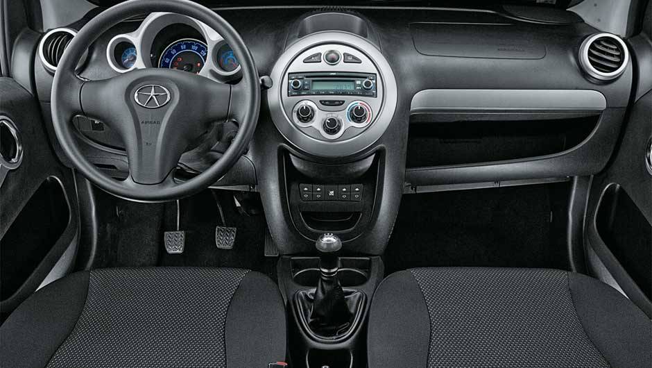 Painel n&atilde;o tem porta-luvas, apenas um compartimento aberto. Sa&iacute;da de ar central &eacute; fixa e n&atilde;o est&aacute; bem posicionada | <a href="https://quatrorodas.abril.com.br/salao-do-automovel/2012/carros/j2-703930.shtml" rel="migration">Leia mais</a>