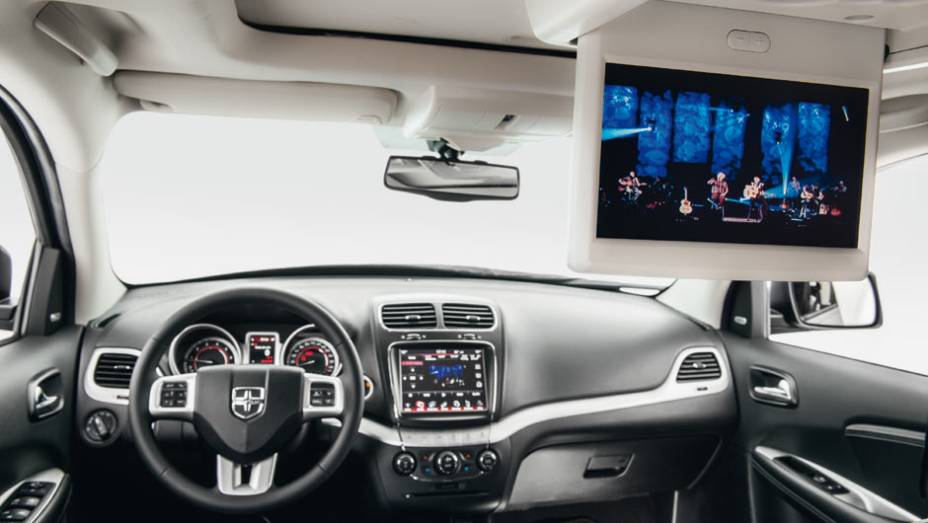 Display de 9 polegadas atrás e 8,4 no painel | <a href="https://quatrorodas.abril.com.br/carros/testes/dodge-journey-837760.shtml" target="_blank" rel="migration">Leia mais</a>