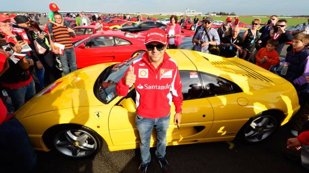 Piloto da Ferrari posou para fotos com os modelos | <a href="https://quatrorodas.abril.com.br/noticias/fabricantes/ferrari-consegue-reunir-964-modelos-marca-silverstone-702287.shtml" rel="migration">Leia mais</a>