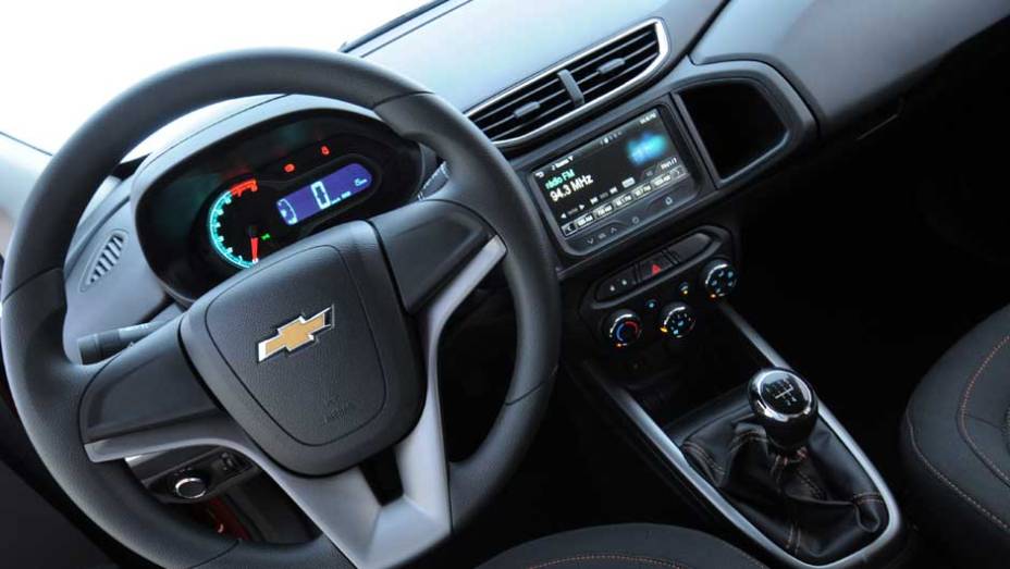 O painel traz várias peças em comum com outros carros da GM, como o volante vindo do sedã Cruze | <a href="%20https://quatrorodas.abril.com.br/salao-do-automovel/2012/carros/onix-708485.shtml" rel="migration">Leia mais</a>