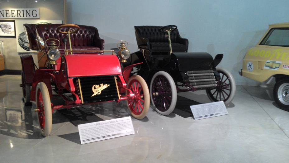 Duas raridades: o Cadillac Runabout 1902, uma espécie de carruagem com um motor de apenas 6,5 cv, e o Cadillac Model A, o primeiro modelo de grande volume fabricado pela marca | <a href="https://quatrorodas.abril.com.br/reportagens/classicos/visitamos-gm-h" rel="migration"></a>