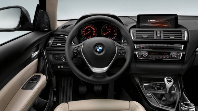 A cabine traz um sistema multimídia montado no console central com tela de 6,5 polegadas e controle por meio de botão | <a href="https://quatrorodas.abril.com.br/noticias/saloes/genebra-2015/bmw-oficializa-facelift-serie-1-826700.shtml" rel="migration">Leia mais</a>