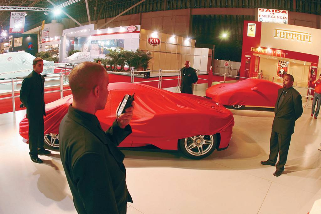 Seguranças vigiando as Ferrari Enzo no estande da marca, antes da abertura do Sa