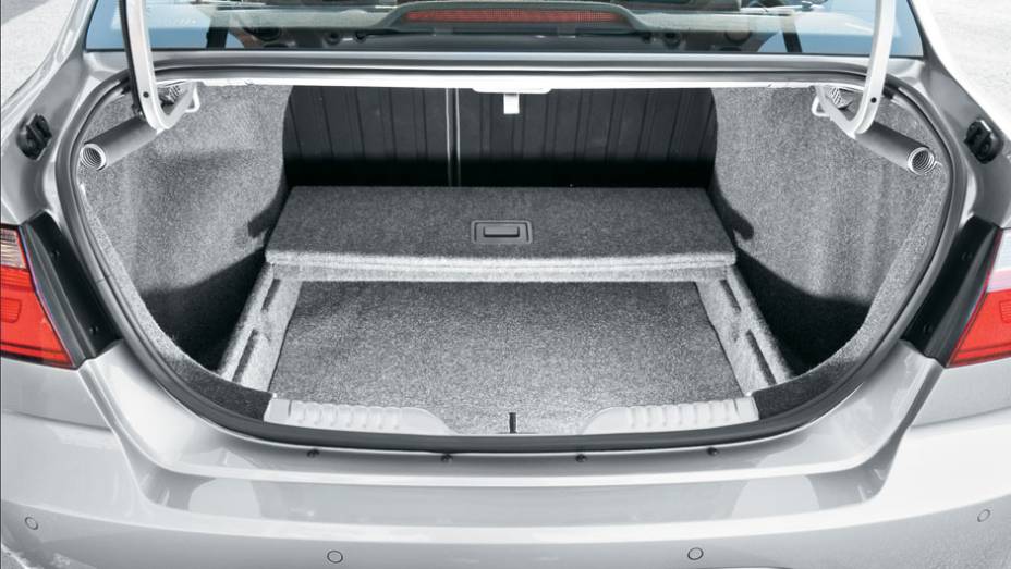 Caixa opcional cria fundo falso no porta-malas | <a href="https://quatrorodas.abril.com.br/carros/lancamentos/vw-voyage-comfortline-699016.shtml" rel="migration">Leia mais</a>