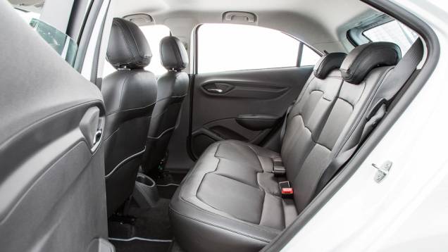 Atrás, o espaço é aceitável para dois adultos, mas falta encosto no meio | <a href="https://quatrorodas.abril.com.br/carros/testes/chevrolet-onix-725300.shtml" rel="migration">Leia mais</a>