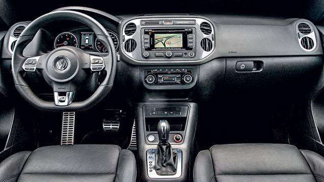 Interior possui volante de três raios com base achatada | <a href="https://quatrorodas.abril.com.br/carros/lancamentos/vw-tiguan-r-line-726908.shtml" rel="migration">Leia mais</a>