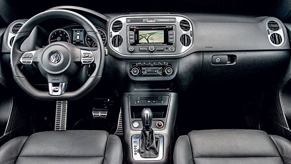 Interior possui volante de tr&ecirc;s raios com base achatada | <a href="https://quatrorodas.abril.com.br/carros/lancamentos/vw-tiguan-r-line-726908.shtml" rel="migration">Leia mais</a>