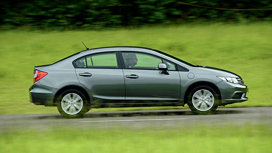 Vers&atilde;o 1.8 tem o sistema de partida a frio tradicional, da&iacute; a perman&ecirc;ncia do segundo bocal no para-lama dianteiro | <a href="https://quatrorodas.abril.com.br/carros/testes/honda-civic-2014-735270.shtml" rel="migration">Leia mais</a>