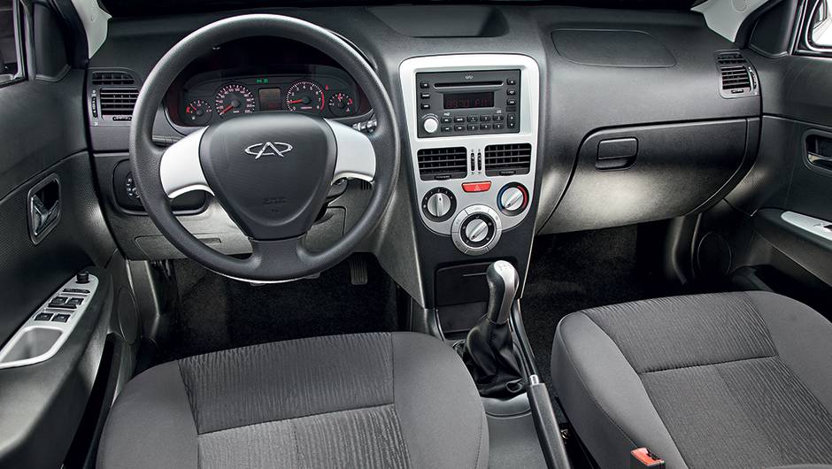 Molduras em console, volante e portas t&ecirc;m um tom de prata diferente do aplique do c&acirc;mbio | <a href="https://quatrorodas.abril.com.br/carros/comparativos/jac-j3-1-5-s-x-chery-celer-1-5-744920.shtml" rel="migration">Leia mais</a>