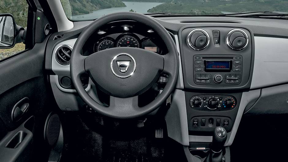Interior farto em acabamento de pl&aacute;sticos duros, inclusive no volante | <a href="https://quatrorodas.abril.com.br/carros/impressoes/dacia-logan-749339.shtml" rel="migration">Leia mais</a>