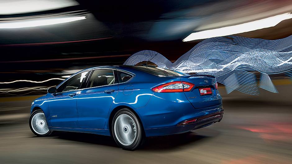 O aerof&oacute;lio traseiro d&aacute; ar esportivo ao modelo | <a href="https://quatrorodas.abril.com.br/carros/testes/ford-fusion-hybrid-757087.shtml" rel="migration">Leia mais</a>