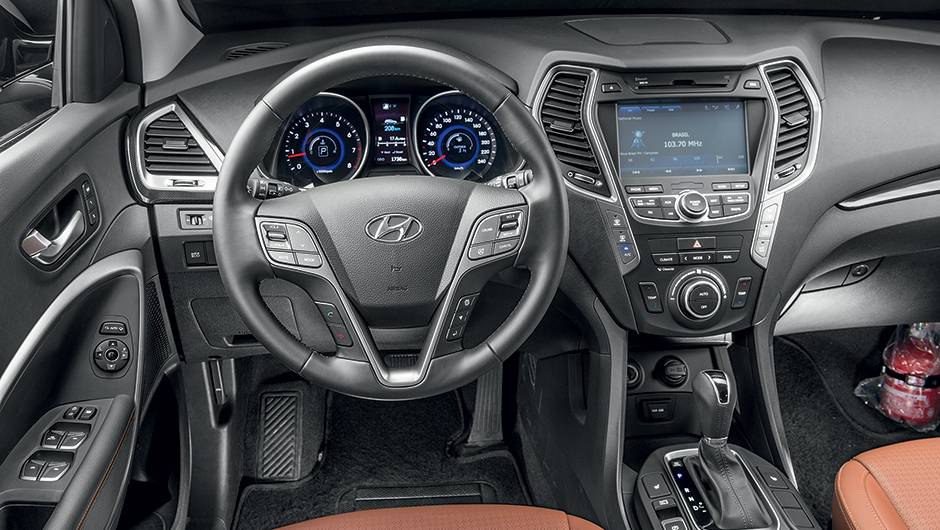 Interior caprichado &eacute; repleto de comandos. H&aacute; at&eacute; um certo exagero de informa&ccedil;&otilde;es | <a href="https://quatrorodas.abril.com.br/carros/impressoes/hyundai-santa-fe-7-lugares-759289.shtml" rel="migration">Leia mais</a>