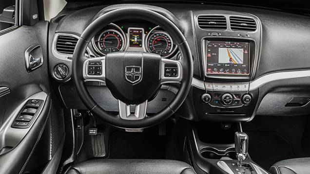 O volante multifuncional leva o emblema da Dodge (no lugar do da Fiat) | <a href="https://quatrorodas.abril.com.br/carros/comparativos/dossie-sete-lugares-120-mil-reais-772708.shtml" rel="migration">Leia mais</a>