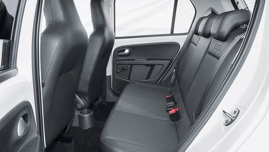 Atr&aacute;s, a altura &eacute; boa, mas lateralmente o espa&ccedil;o &eacute; apertado para tr&ecirc;s. Imita&ccedil;&atilde;o de couro &eacute; opcional | <a href="https://quatrorodas.abril.com.br/carros/testes/volkswagen-up-773936.shtml" rel="migration">Leia mais</a>