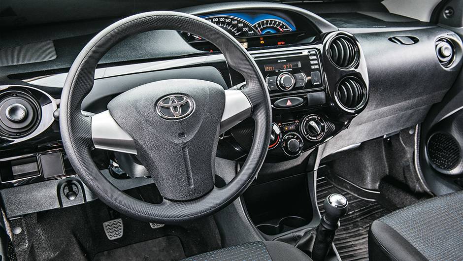 Painel tem tons escuros e um aplique em piano black | <a href="https://quatrorodas.abril.com.br/carros/comparativos/hatches-compactos-779934.shtml" rel="migration">Leia mais</a>