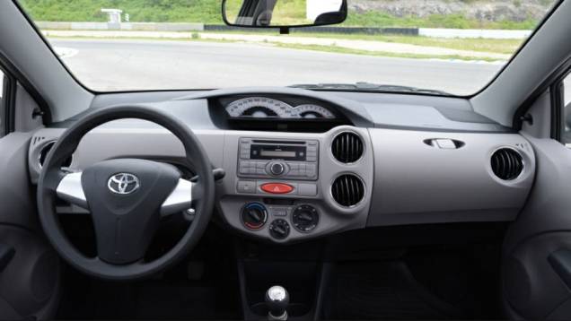 O interior tem materiais simples, como todo popular, e painel em posição central | <a href="https://quatrorodas.abril.com.br/salao-do-automovel/2012/carros/toyota-etios-703992.shtml" rel="migration">Leia mais</a>