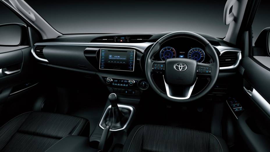 Interior tem conforto de um carro com destaque para a grande tela da central multimídia no painel | <a href="https://quatrorodas.abril.com.br/noticias/fabricantes/toyota-revela-nova-hilux-2016-867763.shtml" rel="migration">Leia mais</a>