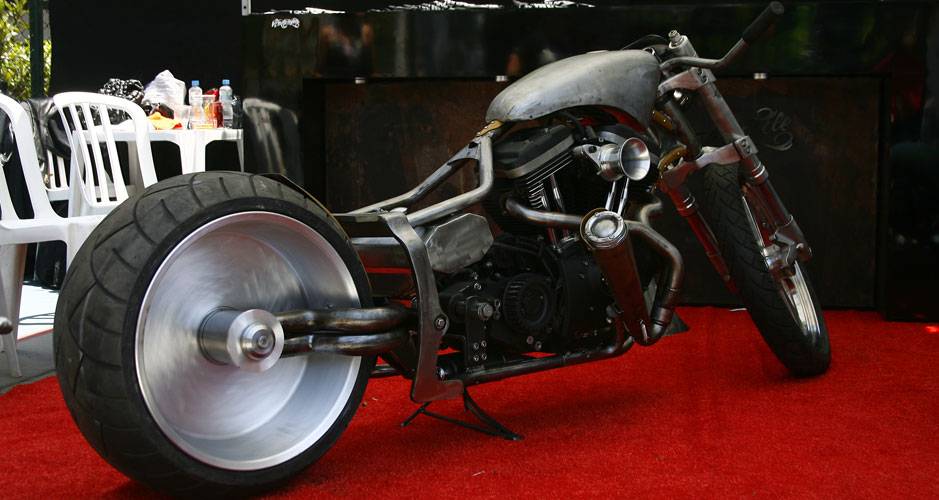 Moto segue o estilo Drag Bike (moto de arrancada) tamb&eacute;m com motor H-D, chassi softail com balan&ccedil;a mono-bra&ccedil;o artesanal, filtro de ar estilo corneta e escape dois em um | <a href="https://quatrorodas.abril.com.br/moto/noticias/two-wheels-brazil-reune-fabric" rel="migration"></a>