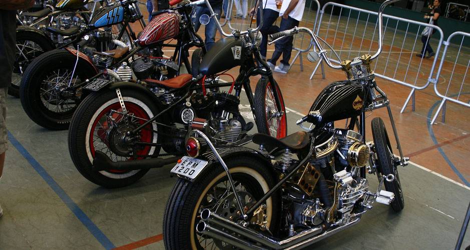 Choppers com frente springer e guid&atilde;o elevado, quadro rabo duro, pneus faixa branca e motores H-D de diferentes gera&ccedil;&otilde;es | <a href="https://quatrorodas.abril.com.br/moto/noticias/two-wheels-brazil-reune-fabricantes-nacionais-americanos-motos-vintage-644346." rel="migration"></a>