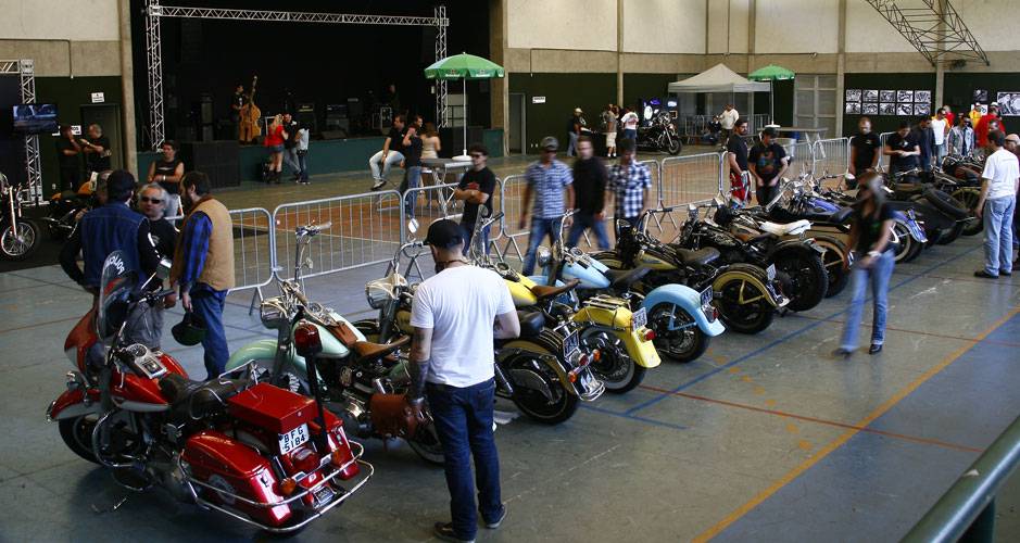 Motos Harley-Davidson customizadas alinhadas no gin&aacute;sio que recebeu o evento Two Wheels na zona sul de S&atilde;o Paulo | <a href="https://quatrorodas.abril.com.br/moto/noticias/two-wheels-brazil-reune-fabricantes-nacionais-americanos-motos-vintage-644346.shtml" rel="migration">Le</a>