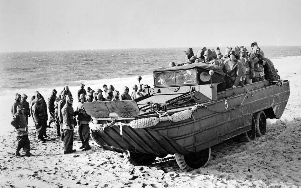 Um veículo anfíbio DUKW carregado com tropas desembarca no litoral francês