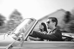 Young fashionable couple in an oldtimer convertible sportscar