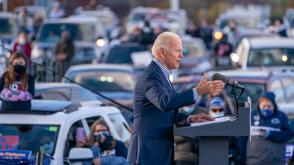 Joe Biden com carros ao fundo 2020