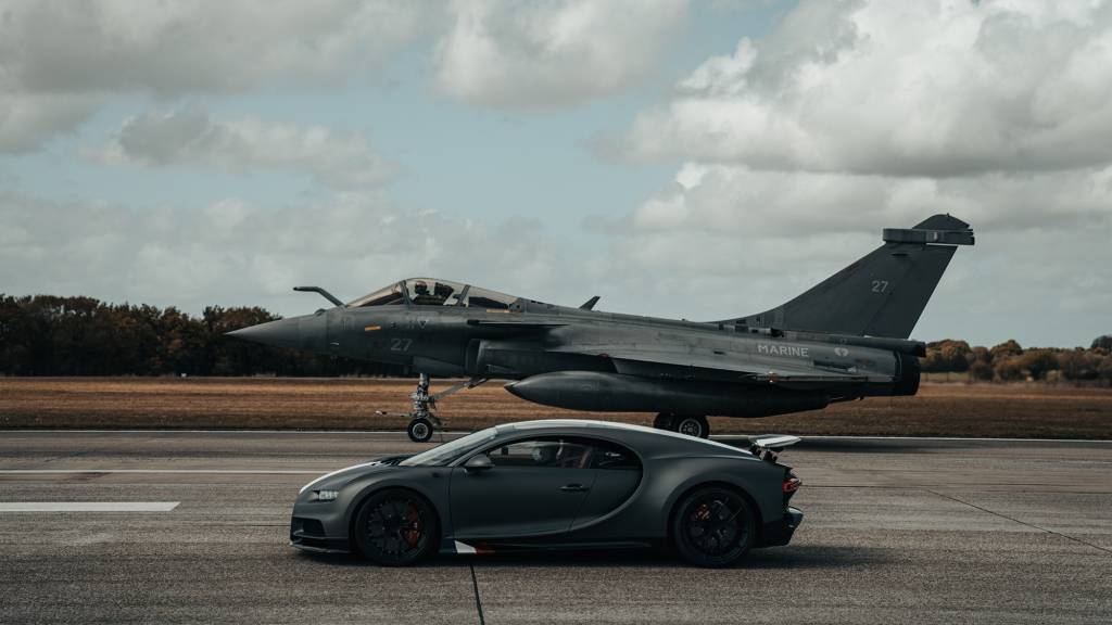Bugatt Chiron Les Legends du Ciel contra Dassault Rafale Marine alinhados lateralmente Bugatt Chiron Les Legends du Ciel contra Dassault Rafale Marine alinhados lateralmente