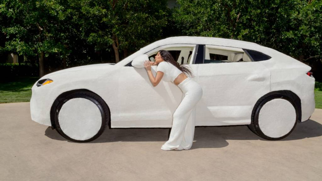 Lamborghini Urus coberto por tecido sintético branco visto de lado