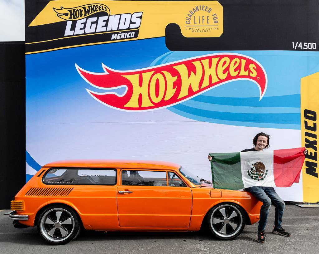 Méxicano posando com a bandeira do país e seu modelo laranja visto de lado