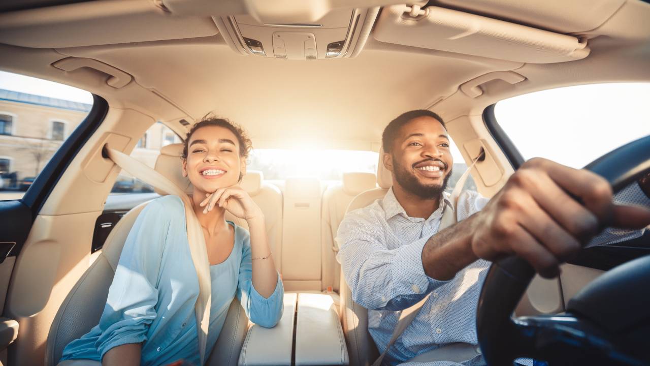 casal dentro de carro dirigindo