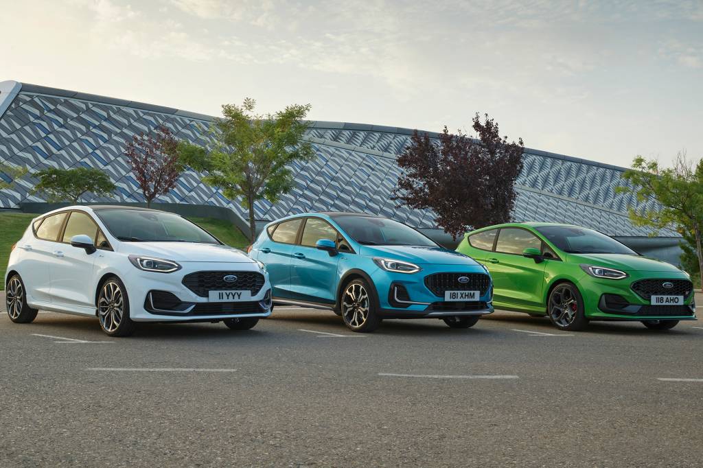 Três Ford Fiesta 2021 branco (esquerda), azul (meio) e verde (direita) vistos 3/4 de frente