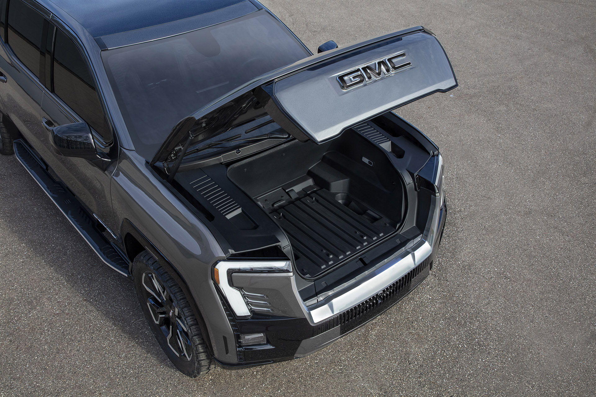 The GMC Sierra EV Denali Edition 1 with the power-operated hood open, showcasing the storage in the front eTrunk.