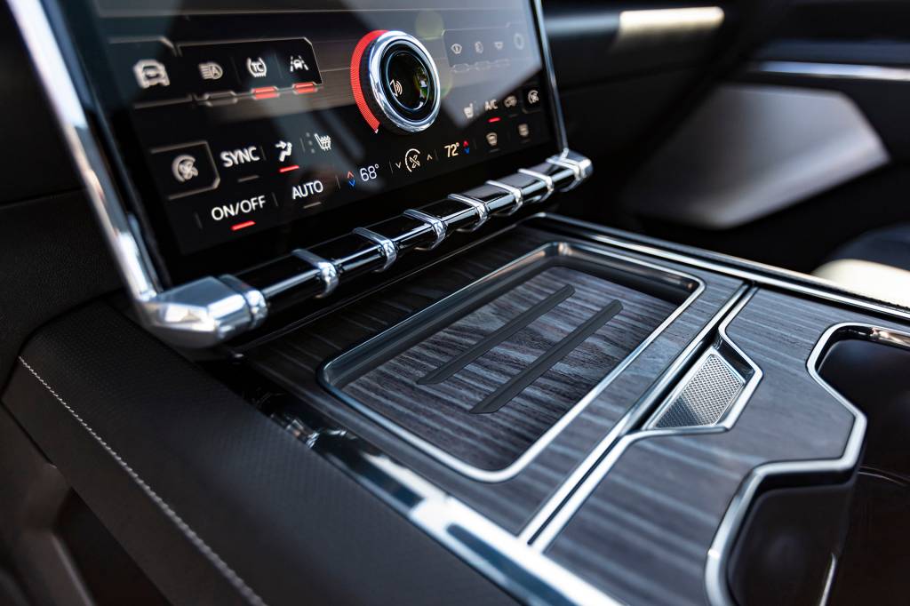The GMC Sierra EV Denali Edition 1 includes unique open pore wood décor and the first implementation of a wood veneer wireless phone charging station.