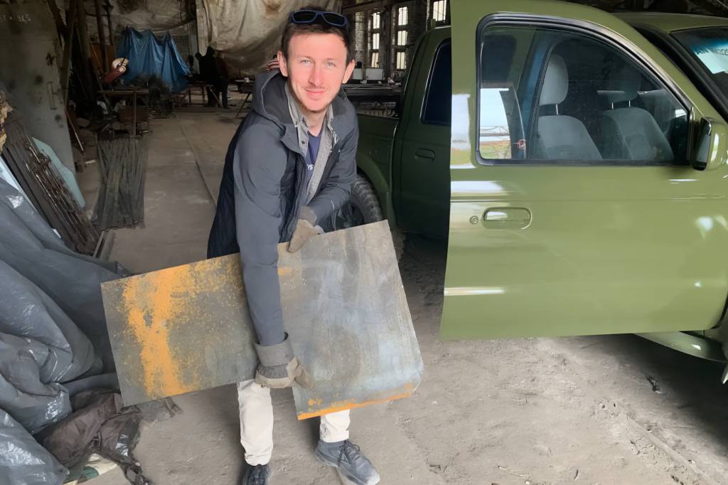 Ivan Oleksii exibe uma das placas de blindagem que são acrescentadas às picapes recebidas Ivan Oleksii exibe uma das placas de blindagem que são acrescentadas às picapes recebidas