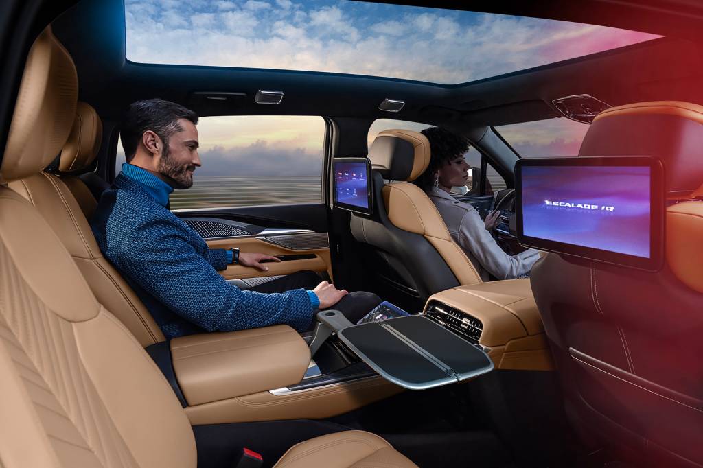 2025 Cadillac ESCALADE IQ Sport Man sitting in Executive Second Row of Cadillac ESCALADE IQ with backseat screens.