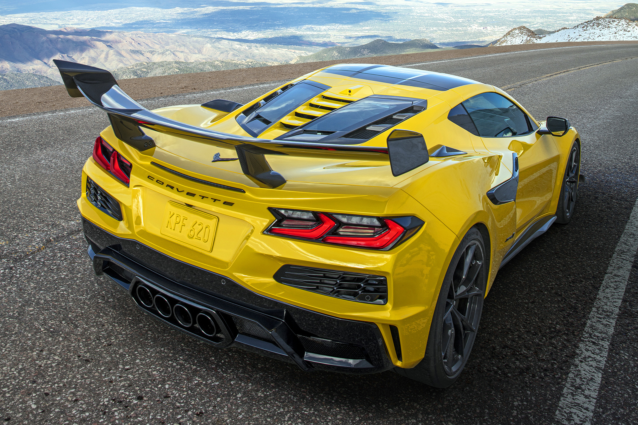 Rear 3/4 view of a Chevrolet Corvette ZR1 Coupe with ZTK Performance Package, highlighting the split-window rear hatch, driving down a mountain road. Preproduction model shown. Actual production model may vary.
