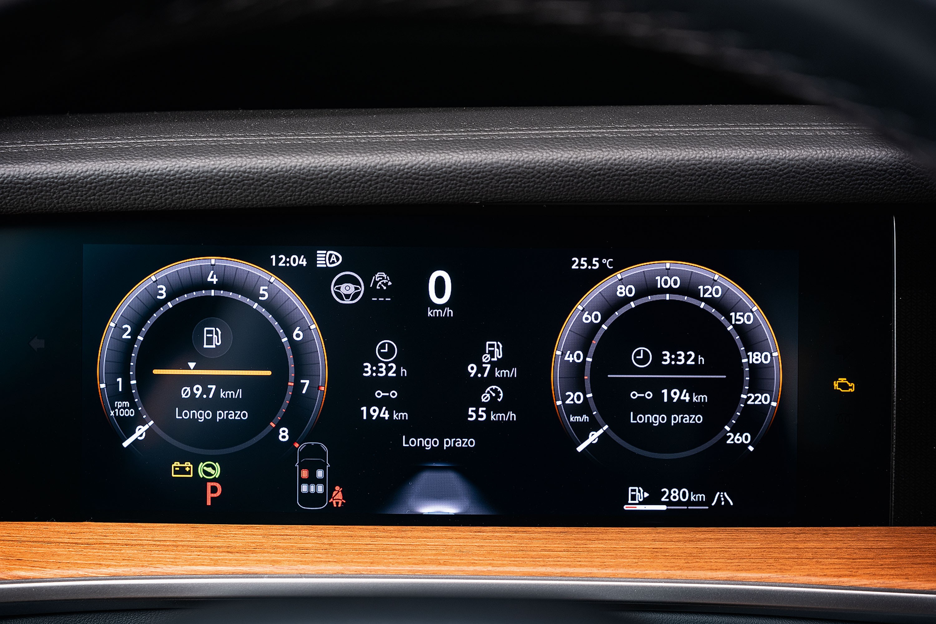 Painel digital de carro com velocímetro e conta-giros, exibindo 0 km/h, consumo de 9.7 km/l, 194 km de autonomia e temperatura de 25.5°C. O fundo é preto com detalhes em laranja e branco, e a parte inferior tem acabamento em madeira