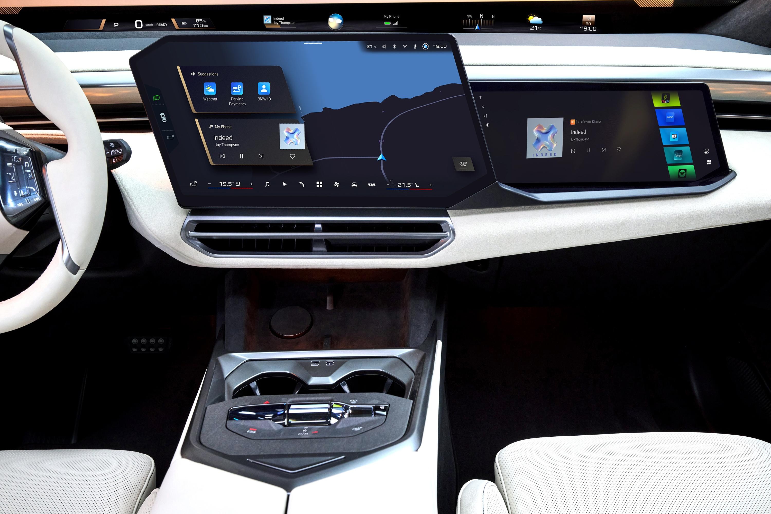 Interior de carro moderno com volante branco à esquerda, painel com duas telas digitais grandes exibindo mapa e aplicativos, e console central com porta-copos e controles. O estofamento é branco, e o ambiente é escuro