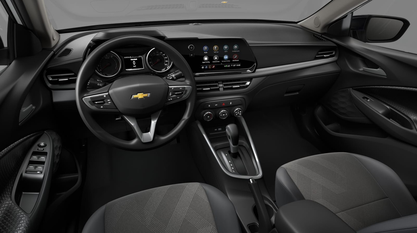 Interior de um carro Chevrolet, com volante multifuncional, painel digital e central multimídia com ícones coloridos. Bancos cinza escuro com detalhes em tecido, câmbio automático e controles no console central. Detalhes em preto e prata, com botões dos vidros na porta do motorista
