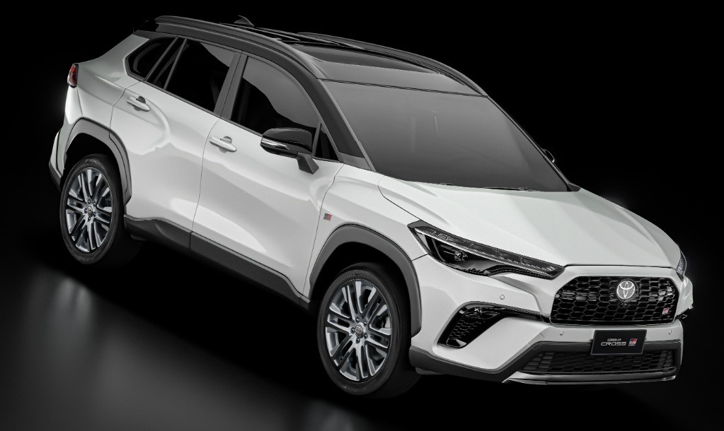 SUV Toyota Corolla Cross branco, com teto e detalhes em preto, rodas esportivas e emblema GR na grade frontal, em um fundo escuro