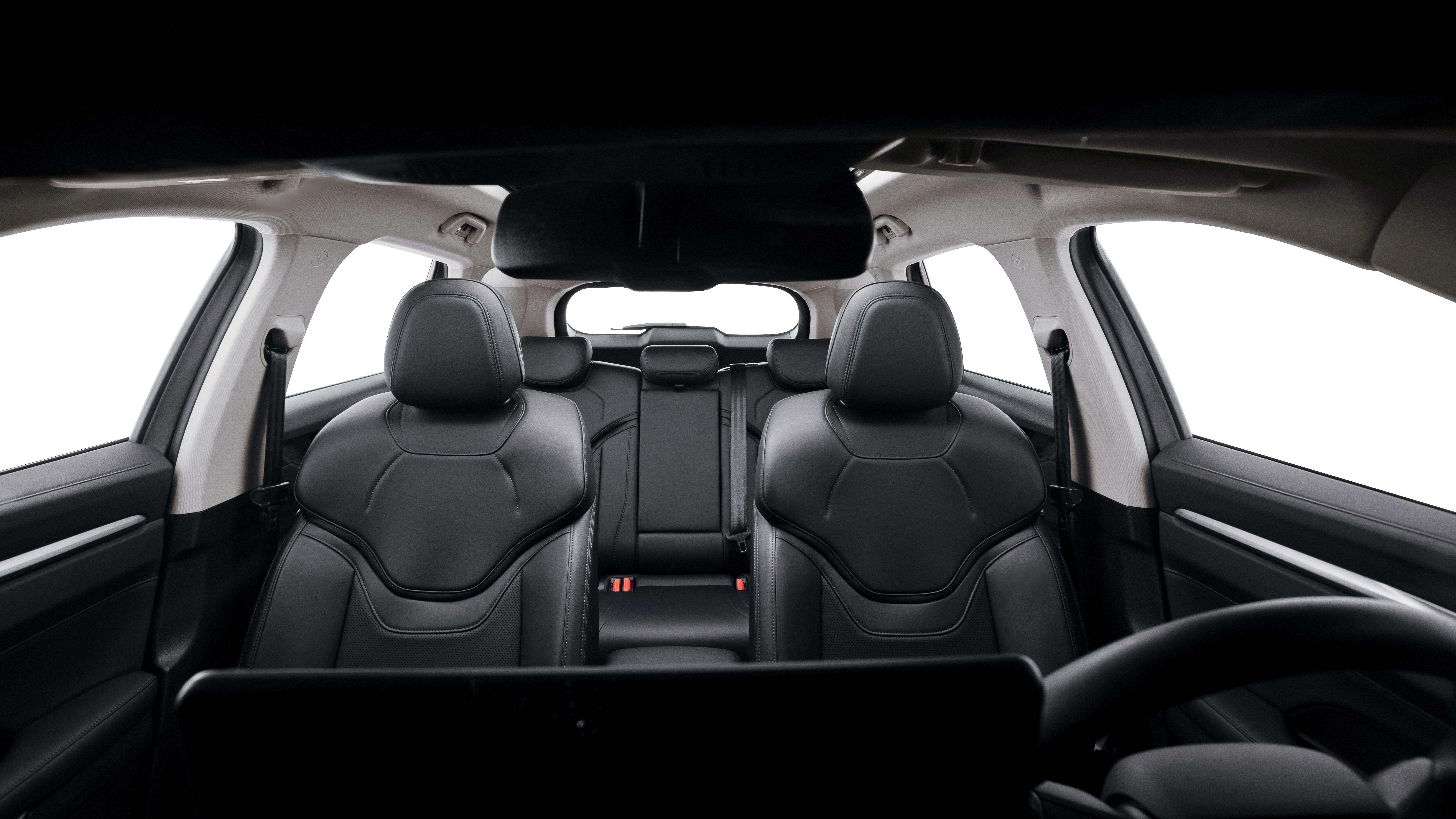 Interior de um carro com bancos de couro pretos, vistos do painel frontal. Os bancos dianteiros e traseiros são visíveis, com janelas brancas ao fundo, sugerindo um estúdio ou fundo claro. O volante aparece parcialmente à direita